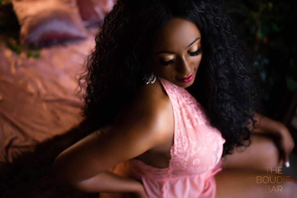 boudoir photo of a black woman wearing pink lingerie