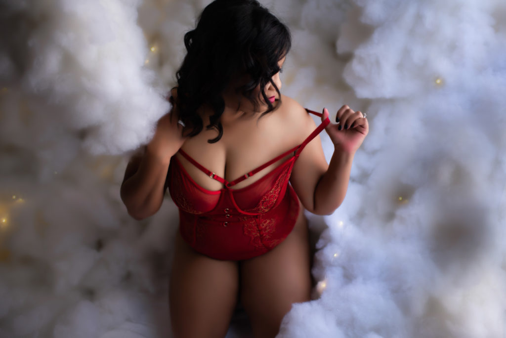 boudoir photo with a woman sitting in clouds wearing red lingerie