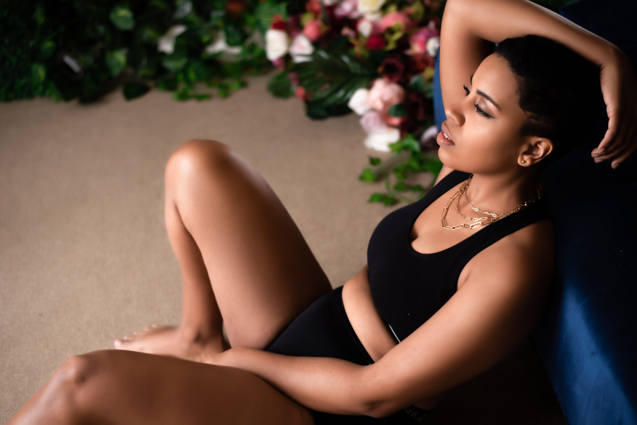black woman relaxing on the floor with flowers surrounding her - simple ways to heal your relationship with your body