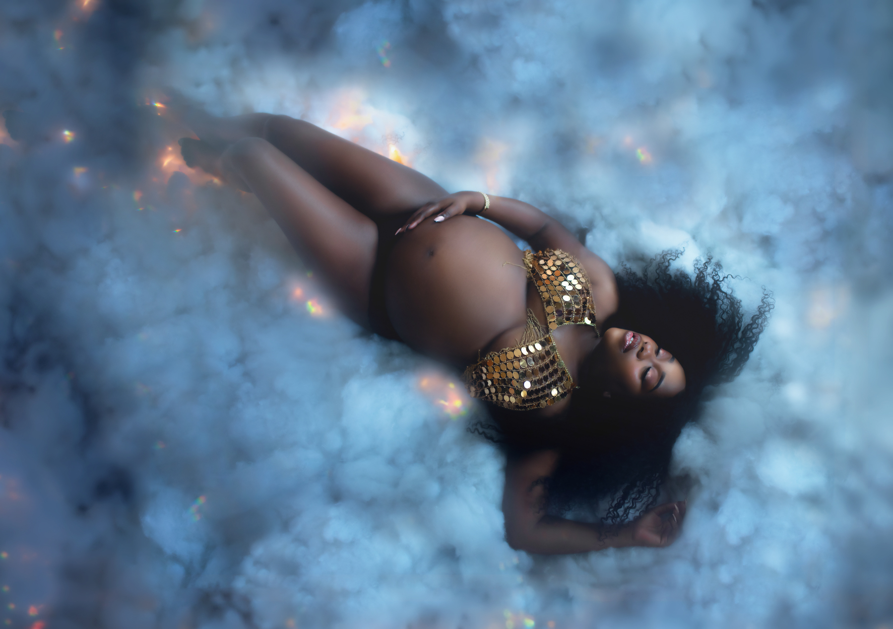 maternity boudoir image of a black woman in storm clouds