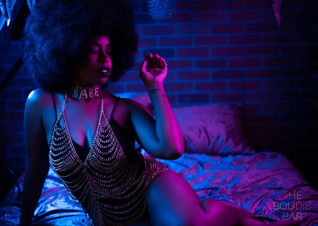 Neon boudoir photo of a black woman with an afro.