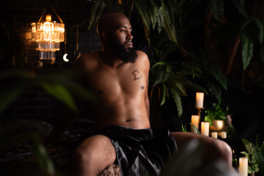 Atlanta Men's Boudoir Photo featuring a black man sitting on a bed.