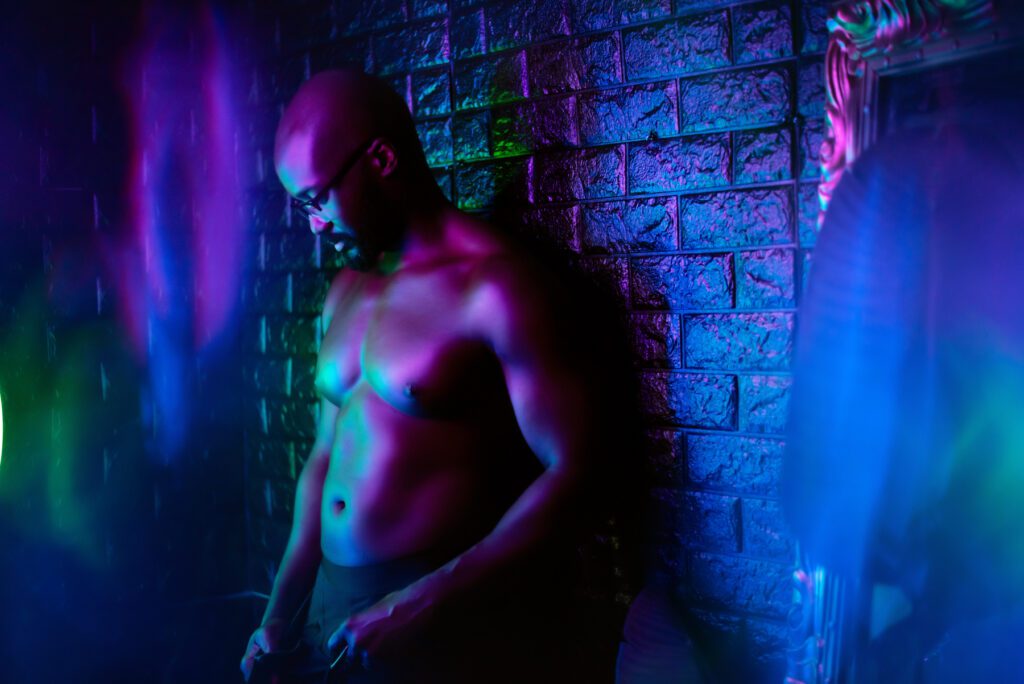 Neon male boudoir photo featuring a man in glasses.