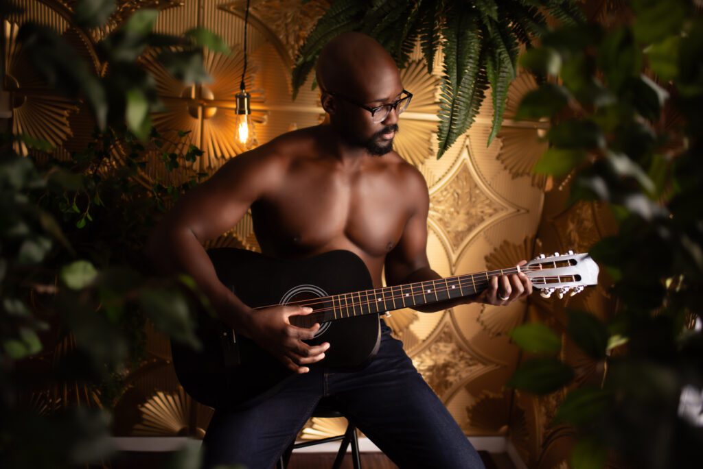 Atlanta boudoir portrait featuring a black man playing a guitar.