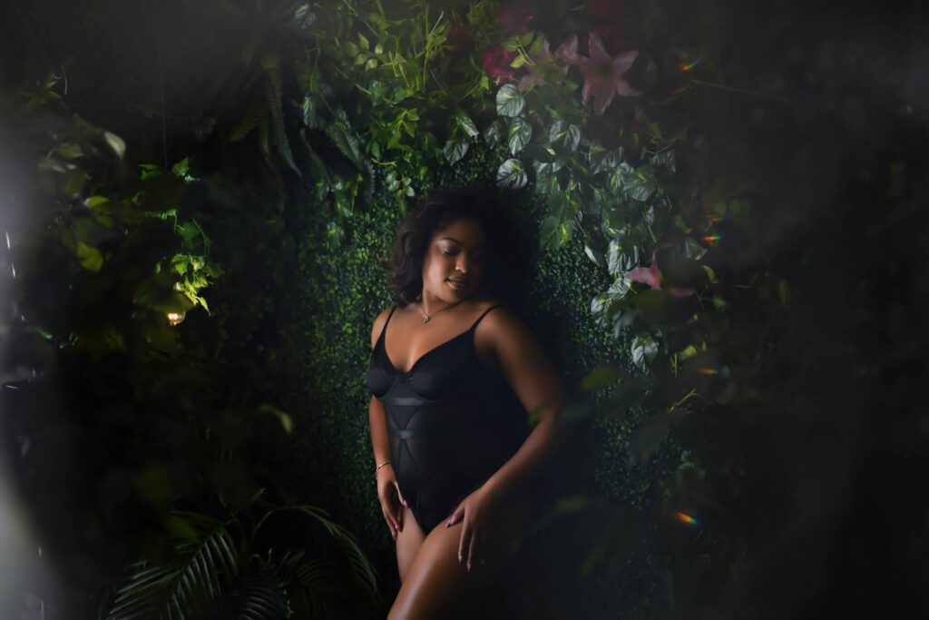 A boudoir photography image of a black woman in a jungle type of setting.